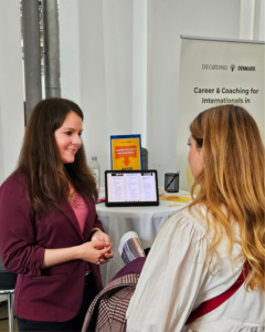 Szilvia from Decoding Denmark speaking with an international at a career and coaching event in Denmark.